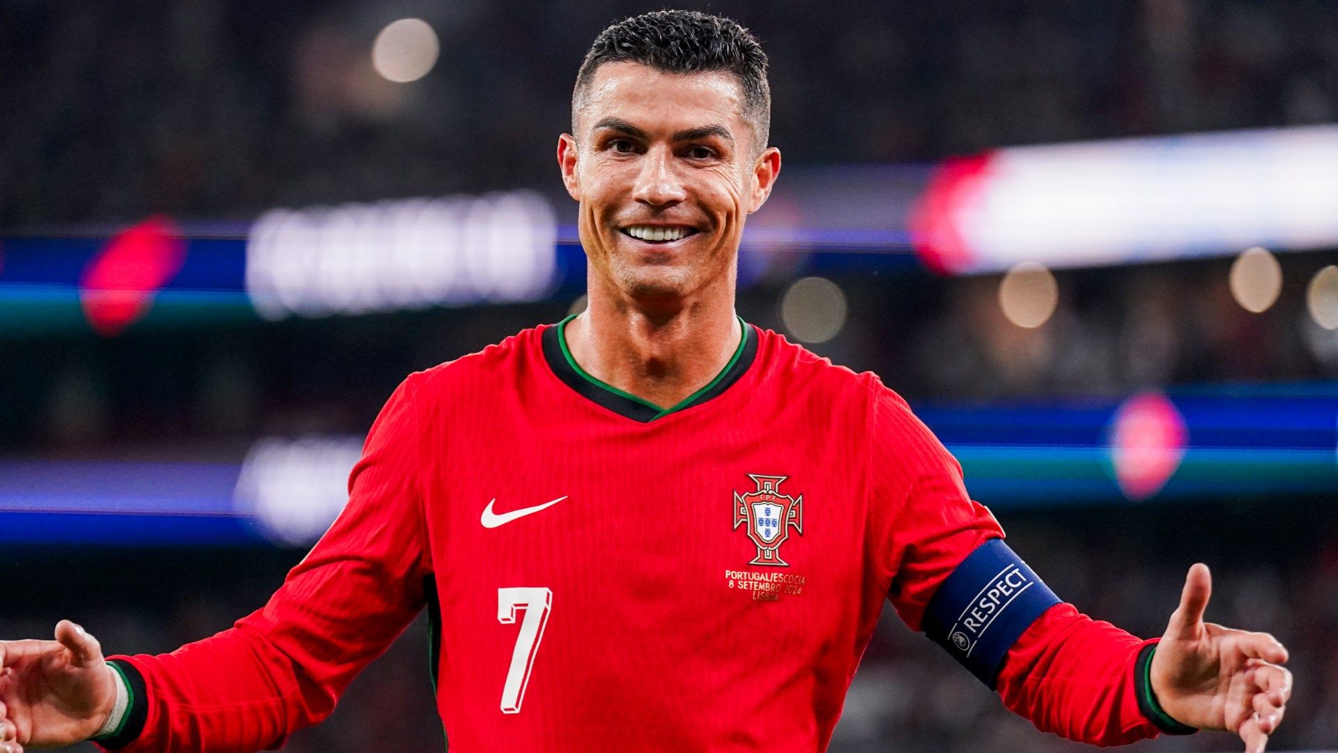 Cristiano Ronaldo smiling in a Portugal jersey during an international match in 2024, wearing captain’s armband.